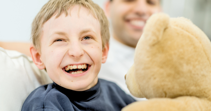 Usměvavý kluk s béžovým medvědem